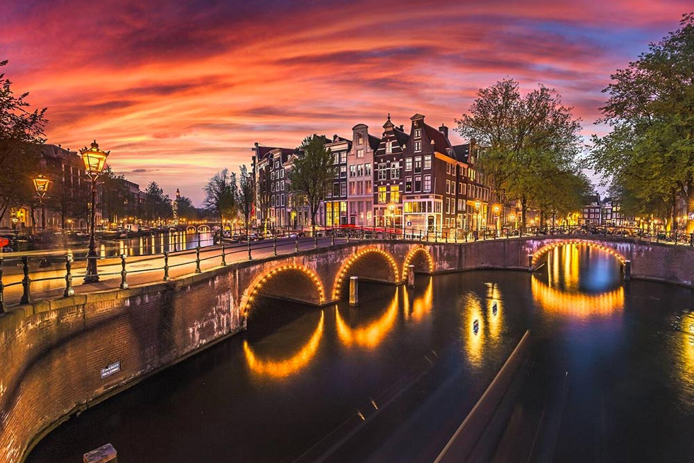 An Amsterdam canal and bridge glowing at sunset, Netherlands